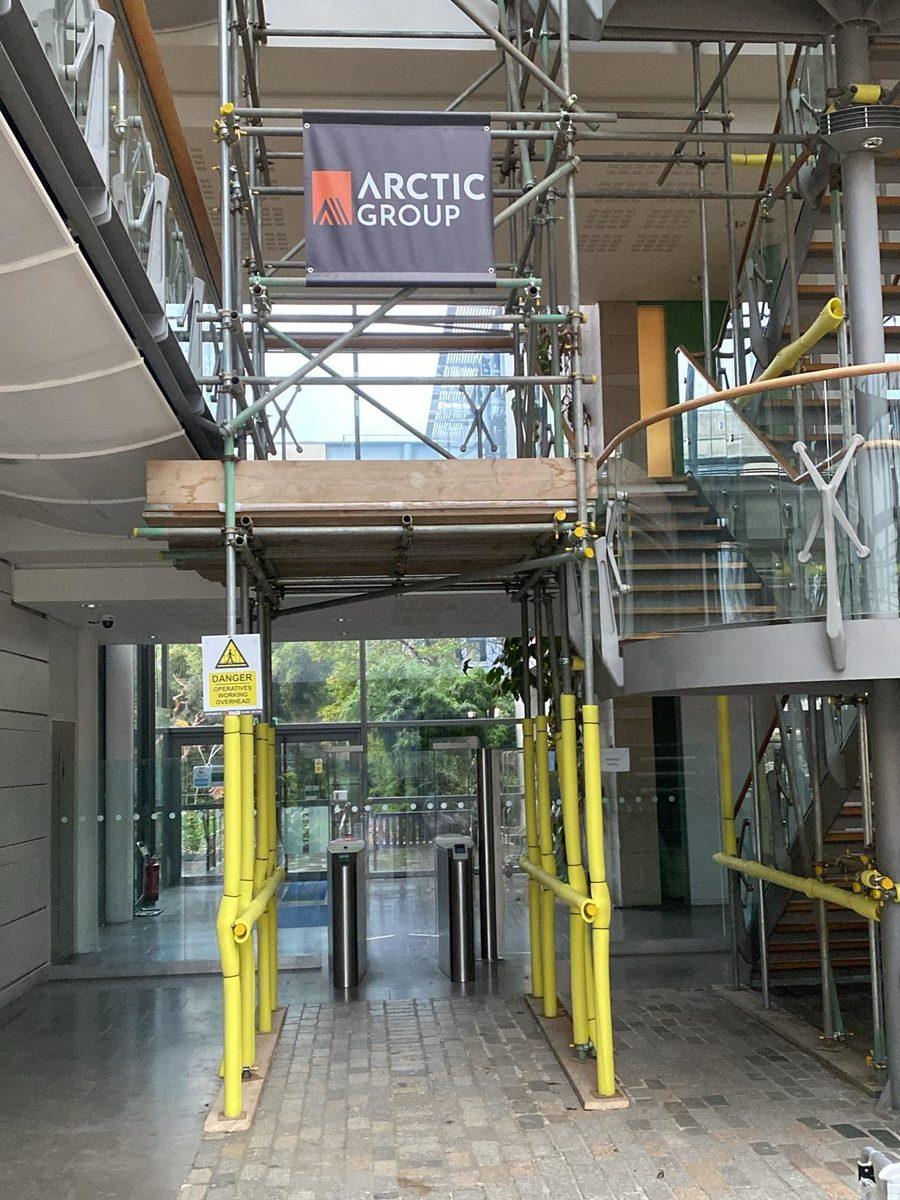 Arctic Group branded scaffold gantry over an office entrance